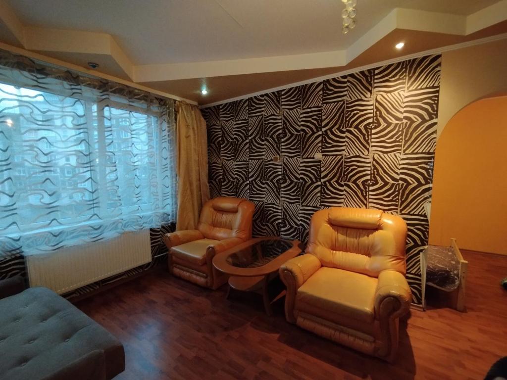 a living room with two chairs and a couch at Airport Apartments in Rīga
