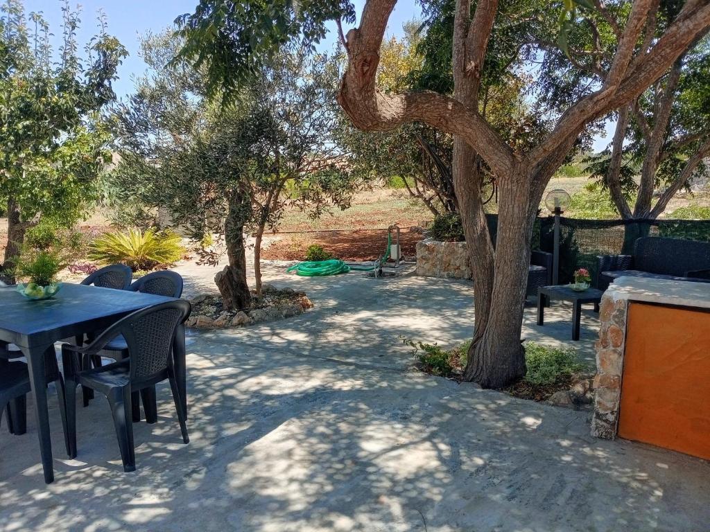 a patio with tables and chairs under trees at Villa Angelica in Capilungo