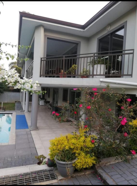 a house with a balcony and flowers in front of it at Bluebird guest house in Kingsborough