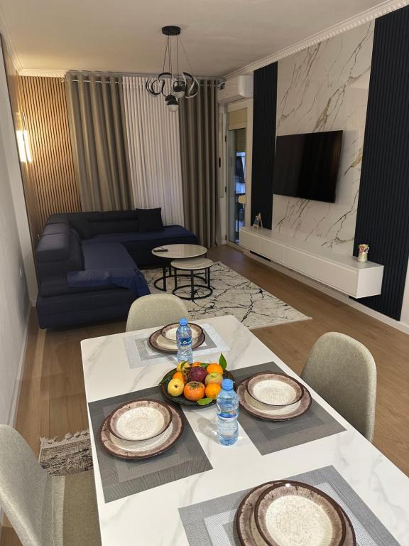 a living room with a table with plates and fruit on it at Steisi Luxe Apartment Tirane in Tirana