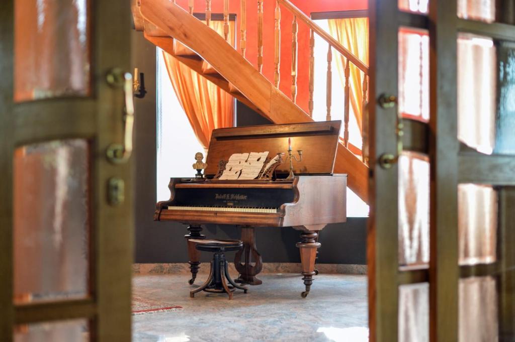 a piano sitting on a stool next to a staircase at Villa Requiem in Bednja