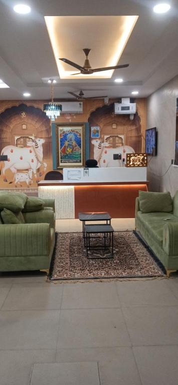 a lobby with two green couches and a table at Shree Hari Das Chamkili Nikunj in Vrindāvan