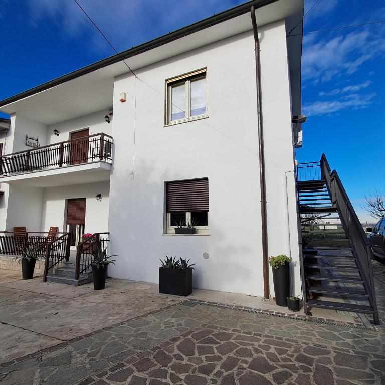 una casa blanca con una escalera al frente en B&B La Magnolia, en Arena Po