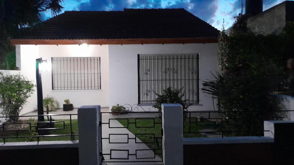 casa super comoda para 6 personas Miramar في ميرامار: بيت ابيض امامه سياج