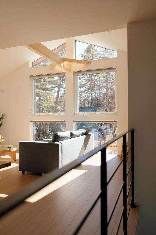 a living room with a couch and two windows at Peak Hakuba 峰白 in Hakuba