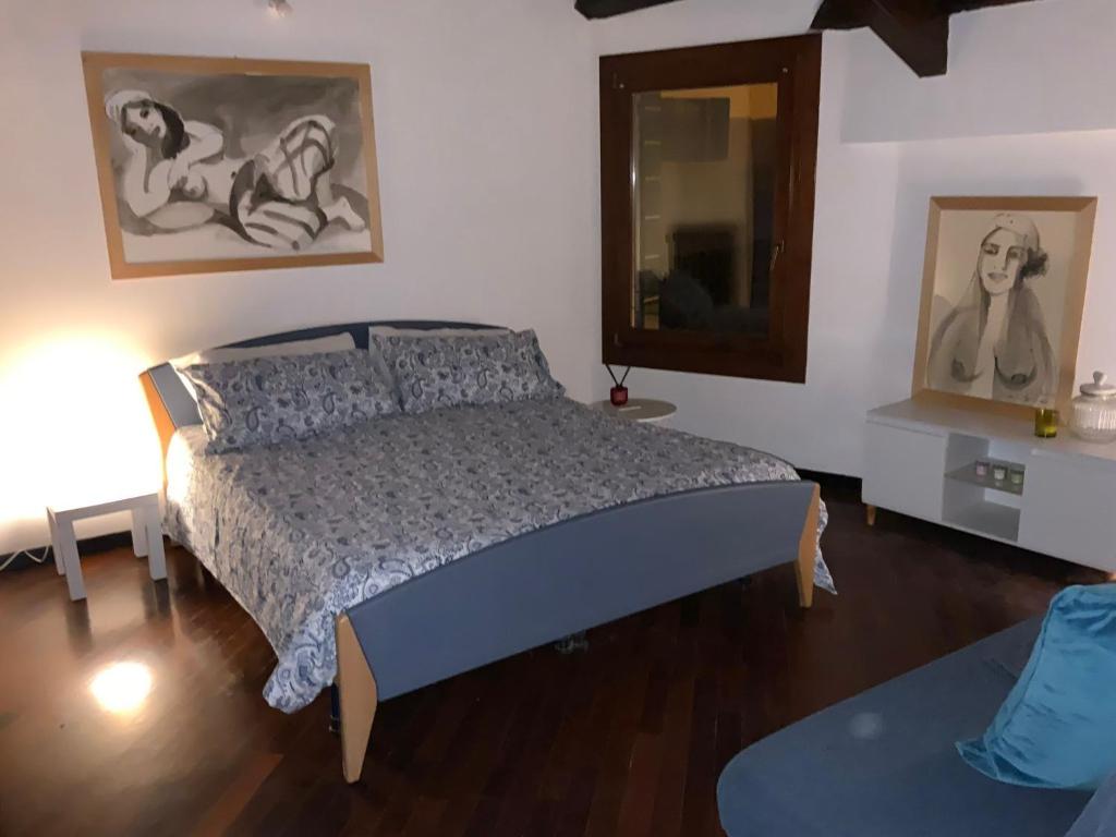 a bedroom with a bed and paintings on the wall at Ca' Molinetto in Treviso