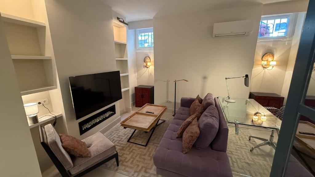 a living room with a couch and a flat screen tv at Stylish Haven in Chic Salamanca in Madrid