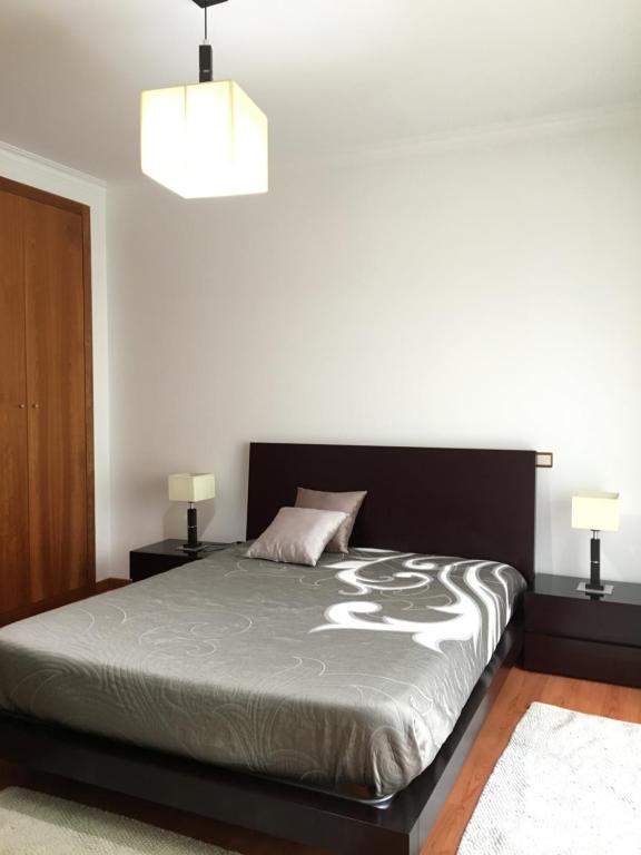 a bedroom with a bed with two night stands at São Martinho do Porto Beach Apartment in São Martinho do Porto