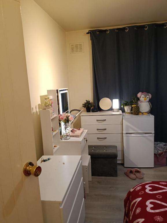 a room with a desk and a dresser with a mirror at Howcroft 