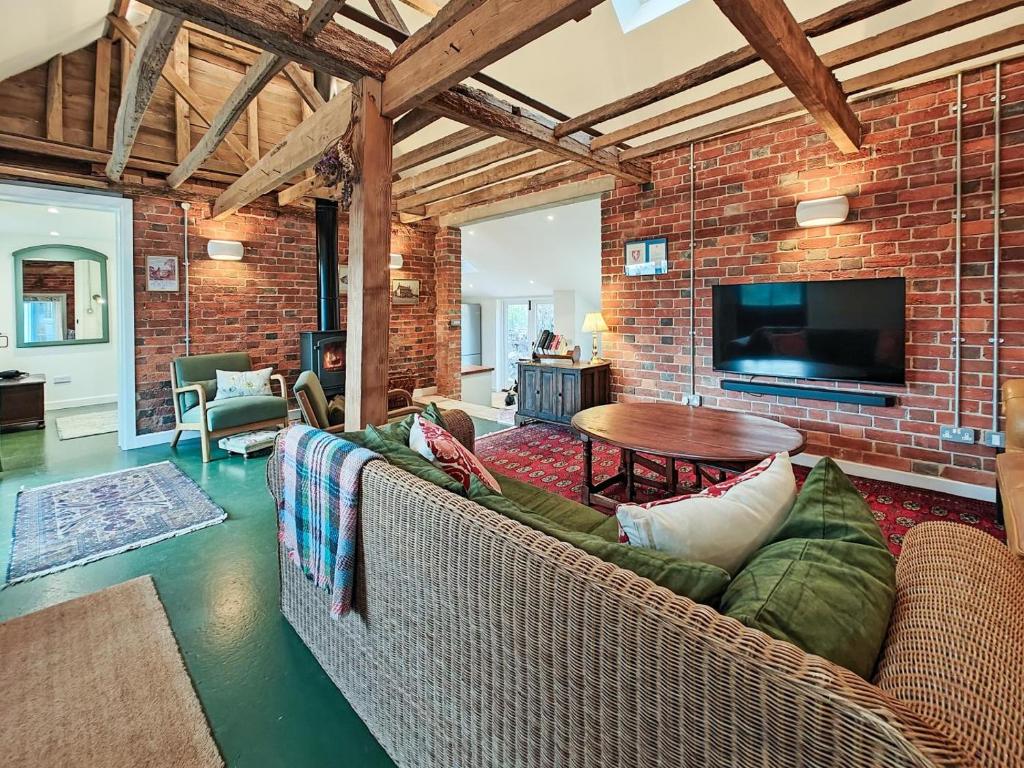 a living room with a couch and a brick wall at 3 Bed in Edenbridge oc-o34127 in Hever