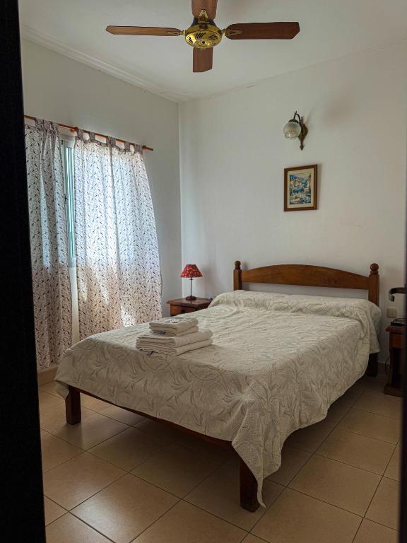 Apart hotel Bonato في La Porteña: غرفة نوم بها سرير ومروحة سقف