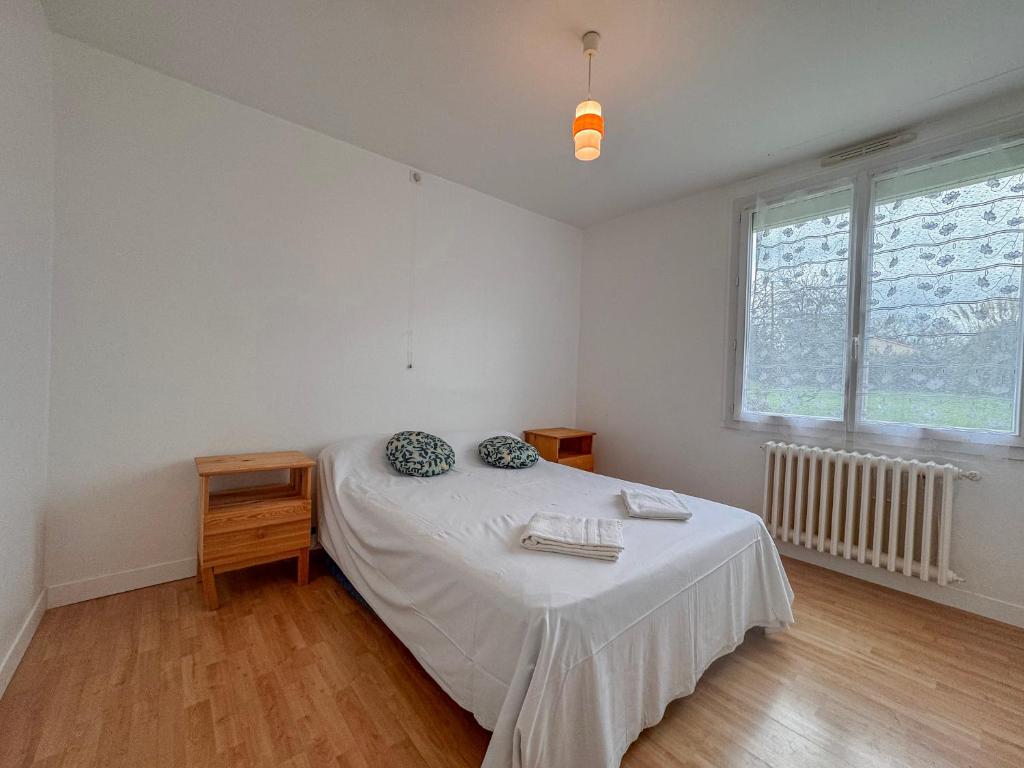 una camera da letto bianca con un letto e una finestra di Domaine Muleterie a Chavagnes-les-Redoux