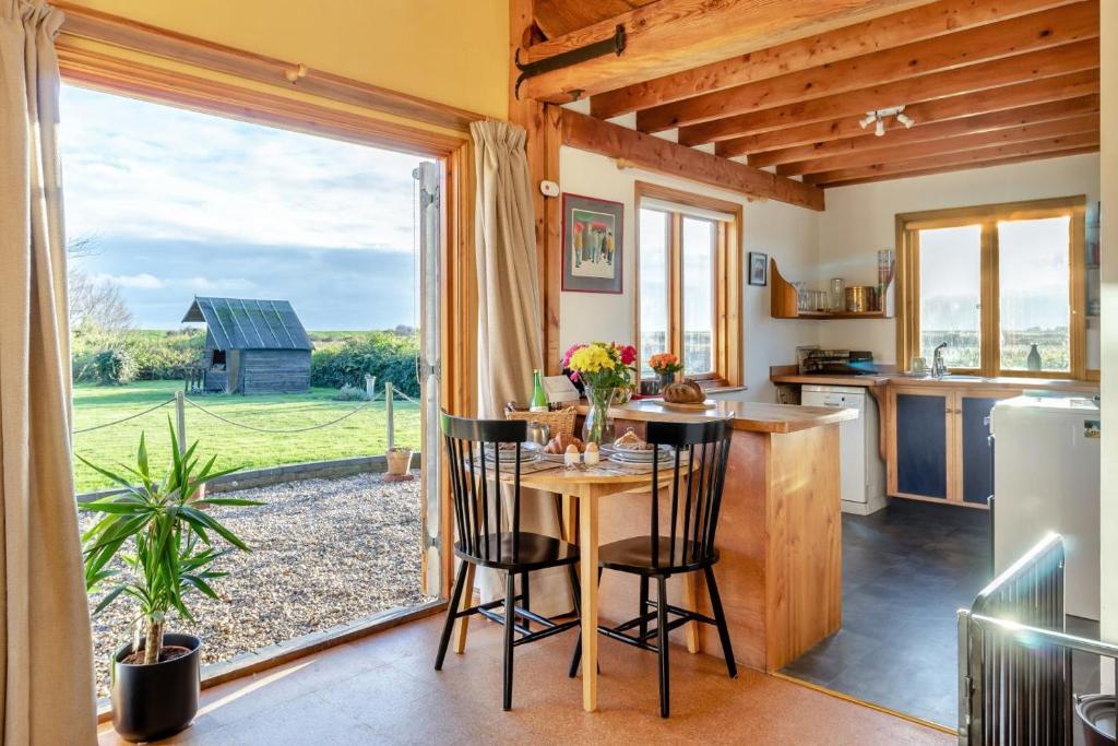 una cucina con tavolo e sedie e una grande finestra di 1 Bed in Orford oc-m34121 a Orford