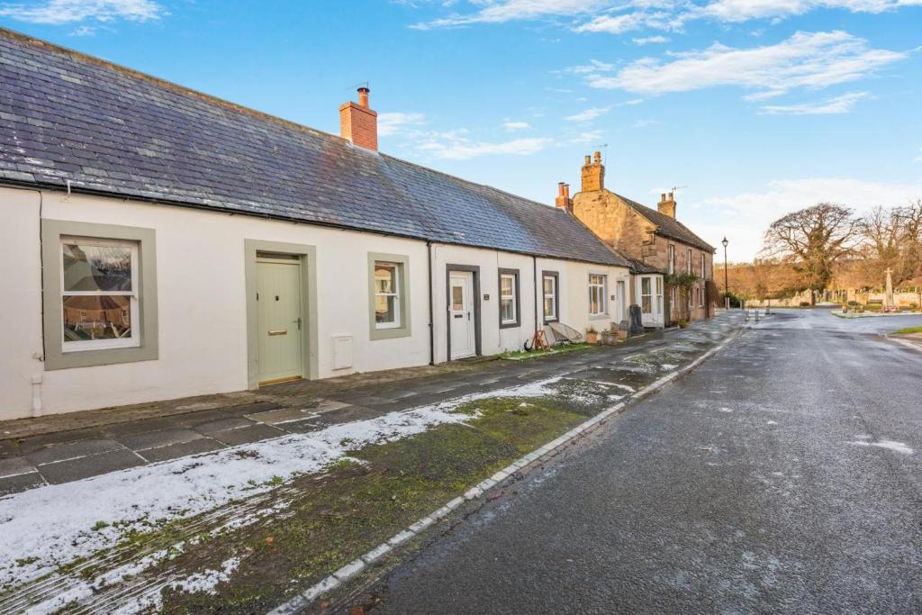 een rij huizen aan een besneeuwde straat bij 2 Bed in Norham oc-p34181 in Norham