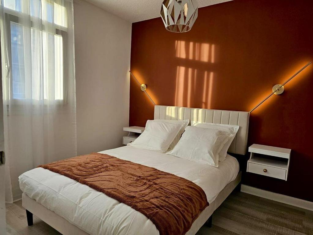ein Schlafzimmer mit einem großen Bett mit einer roten Wand in der Unterkunft Le petit savoyard in Albertville