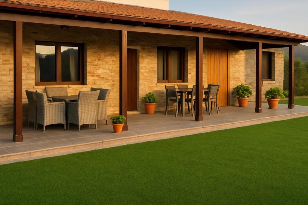 a house with a deck with a table and chairs at ANTHEMIs COTTAGE RED in Kyperounda