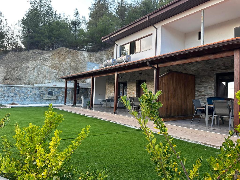 una casa con un prato davanti di ANTHEMIs COTTAGE RED a Kyperounda