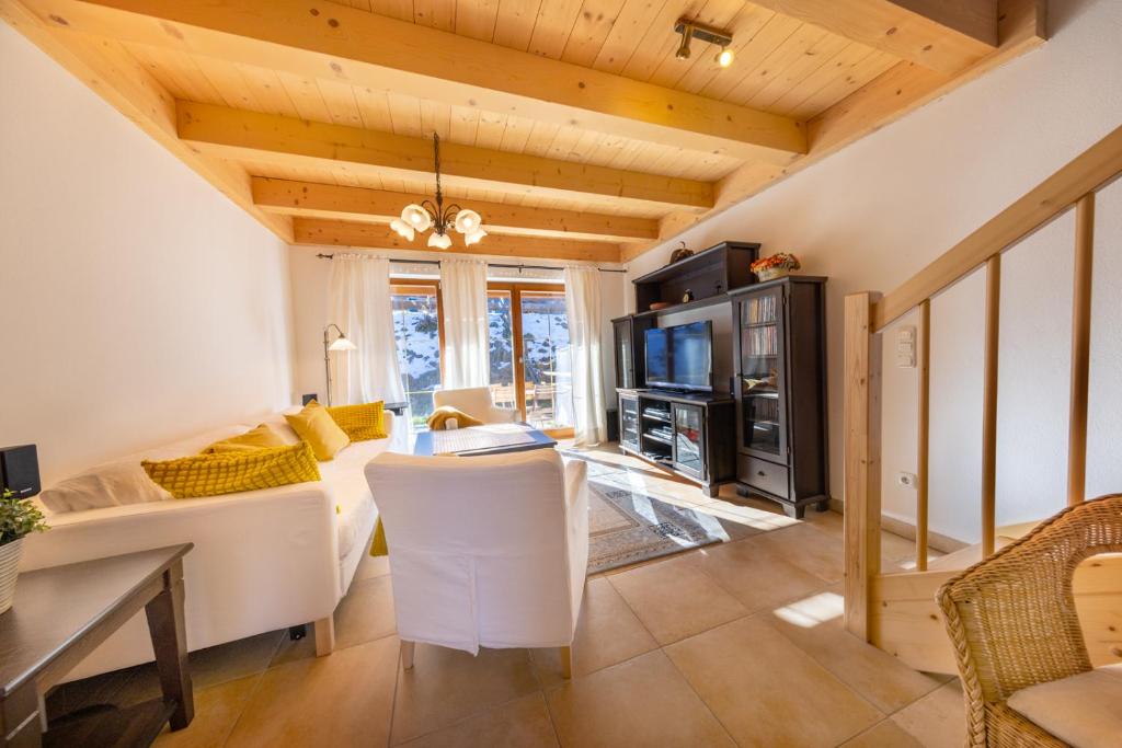 Una sala de estar con un sofá blanco y un televisor. en Haus Alpenruhe, en Königsleiten