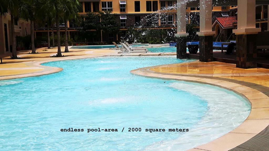 a large pool with blue water in a building at Amalfi Oasis Seaside Cebu in Cebu City