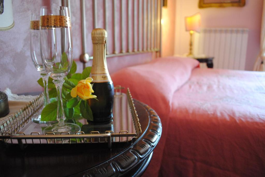 uma garrafa de champanhe numa mesa ao lado de uma cama em B&B Elvira Al Duomo em Monreale