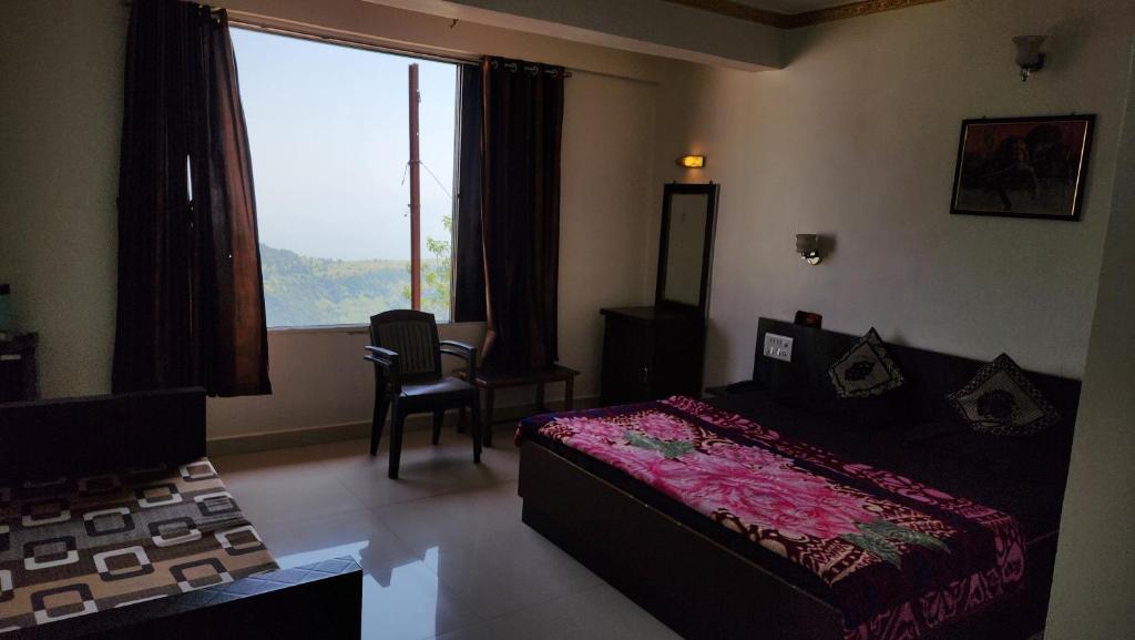 a bedroom with a bed and a large window at Hiral residency in Matheran