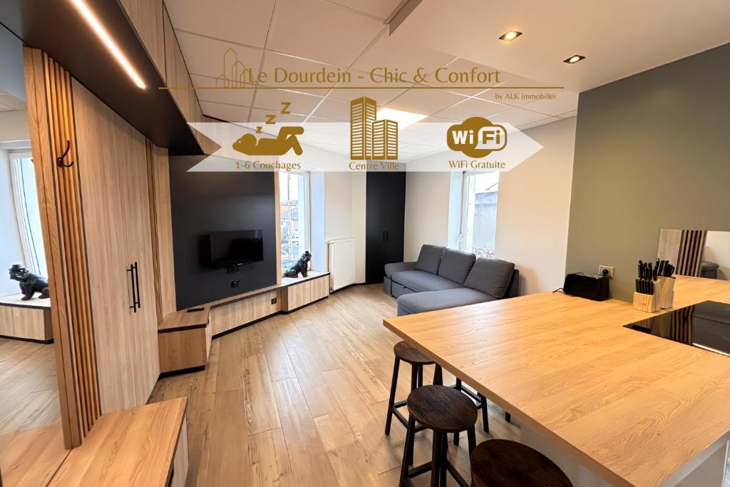 un soggiorno con un tavolo e un divano di Le Dourdein - Chic & Confort a Roanne