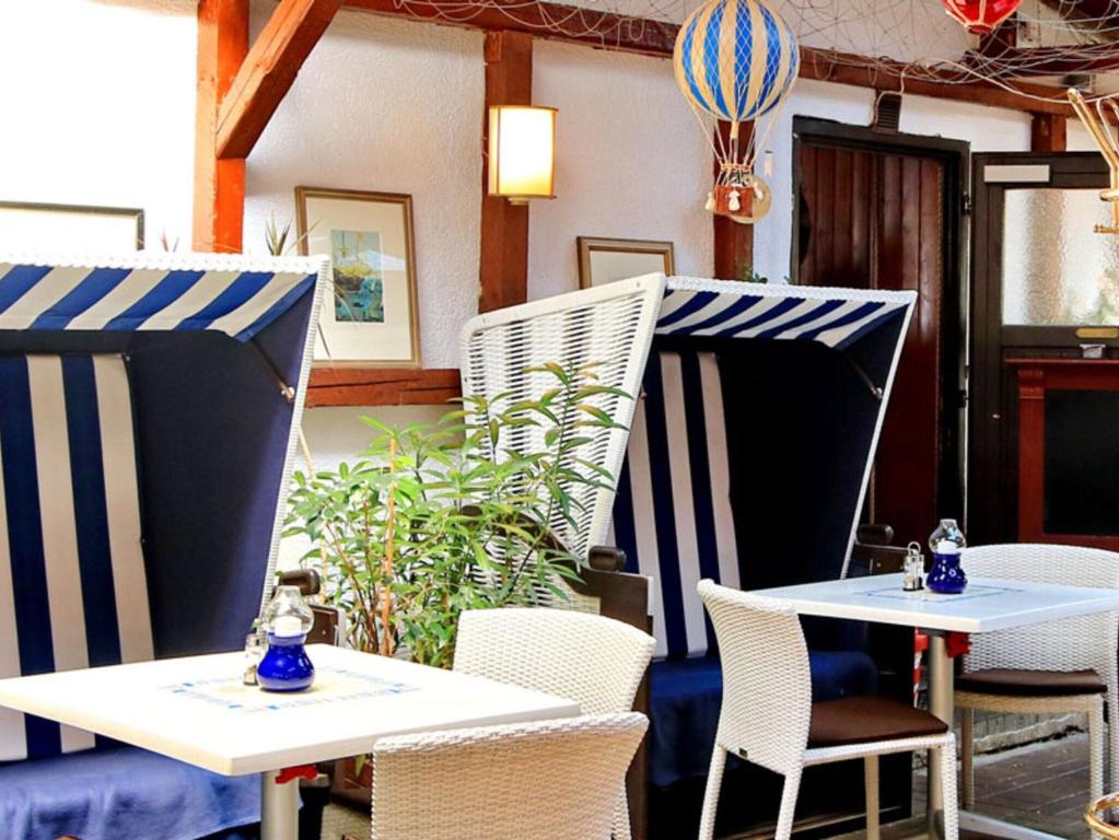 a couple of tables and chairs in a restaurant at Ankes Pension "Koje 7" in Rostock