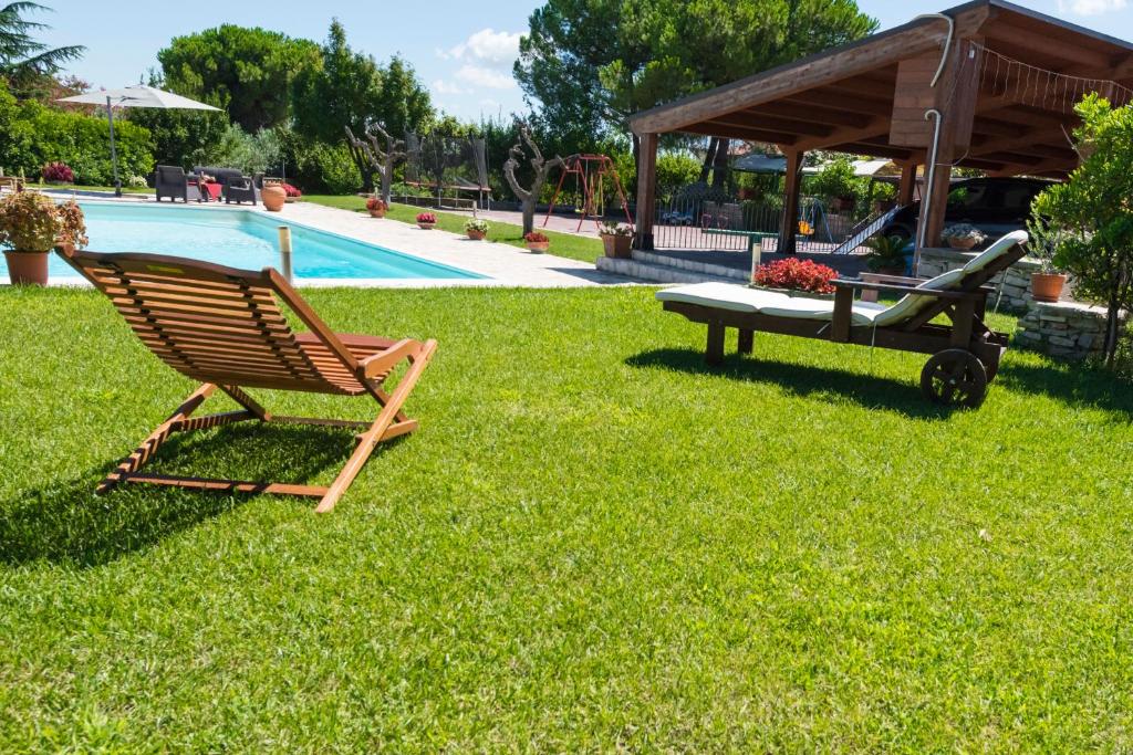 une chaise et une table dans l'herbe à côté d'une piscine dans l'établissement Villa Miranda, à Ortona