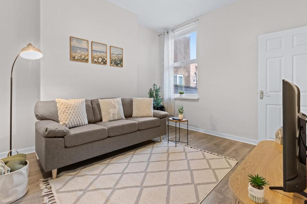 a living room with a couch and a table at Contractors, Free Parking, TV, Discounts, Wi-Fi in Wallasey