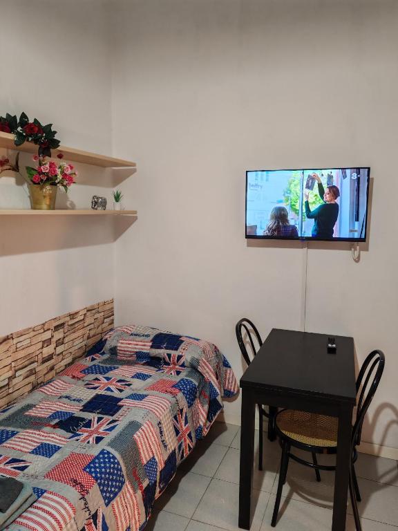 a bedroom with a bed and a table with a tv on the wall at Casa PALLINA FIDENZA in Fidenza