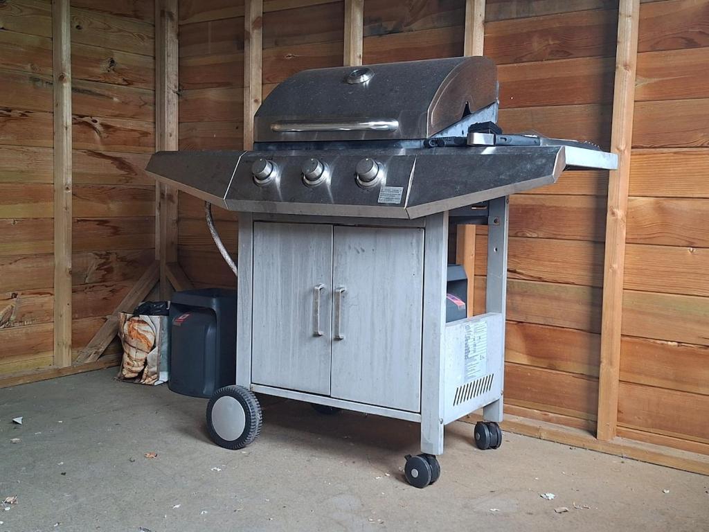 einen Grill in der Ecke eines Hauses in der Unterkunft Le Refuge des Dunes in Bray-Dunes