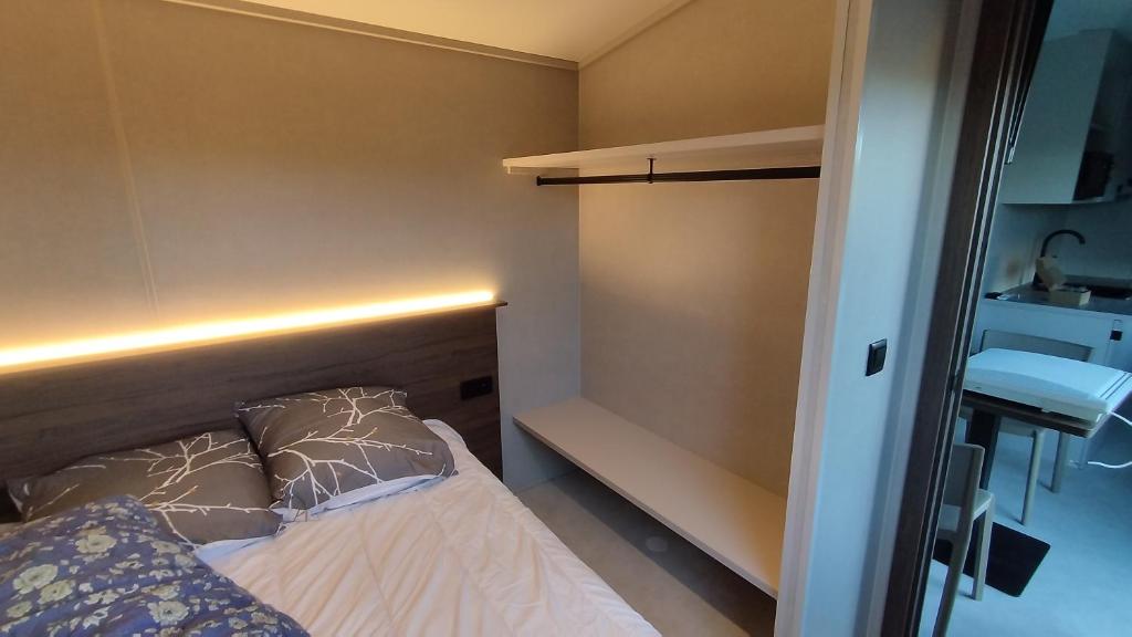 ein kleines Schlafzimmer mit einem Bett und einer Lampe in der Unterkunft Tiny-housse in Peyrins