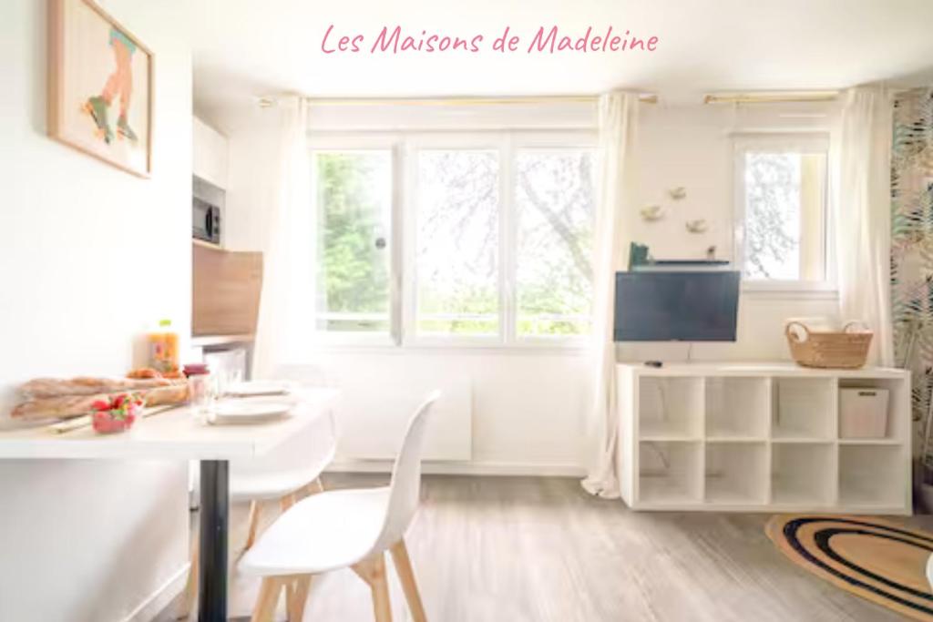 ein Wohnzimmer mit einem weißen Tisch und Stühlen in der Unterkunft Les studios de l'Albatros in Saint-Nazaire