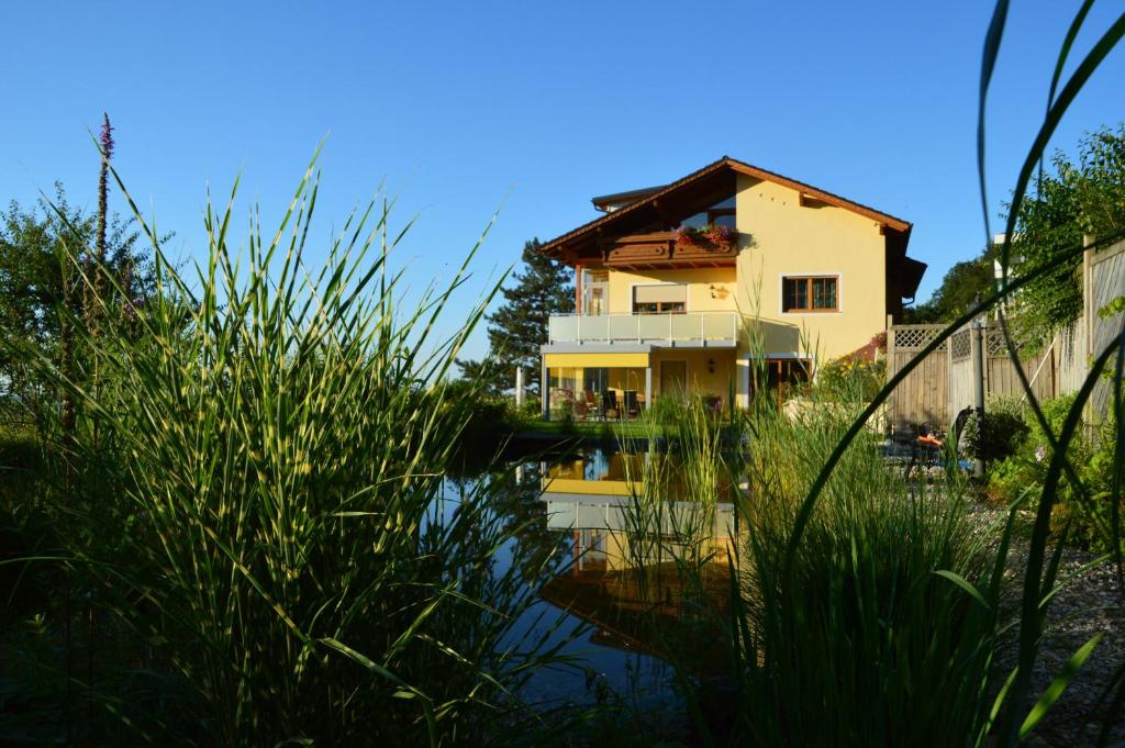 una casa si riflette in un corpo d'acqua di Haus Margit a Schlierbach