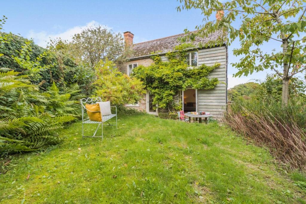 ein altes Haus mit einem Stuhl im Hof in der Unterkunft 3 Bed in Newton St. Margarets oc-o33367 in Saint Margaret