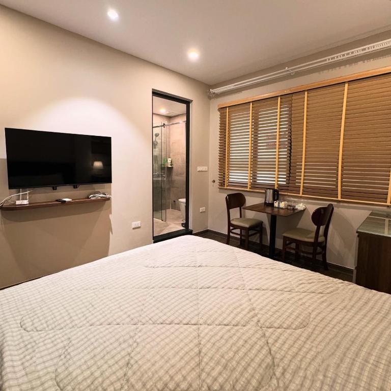 a bedroom with a bed and a tv and a table at Studio 3 ByhomeLinh Phố Cổ Hoàn Kiếm in Hanoi