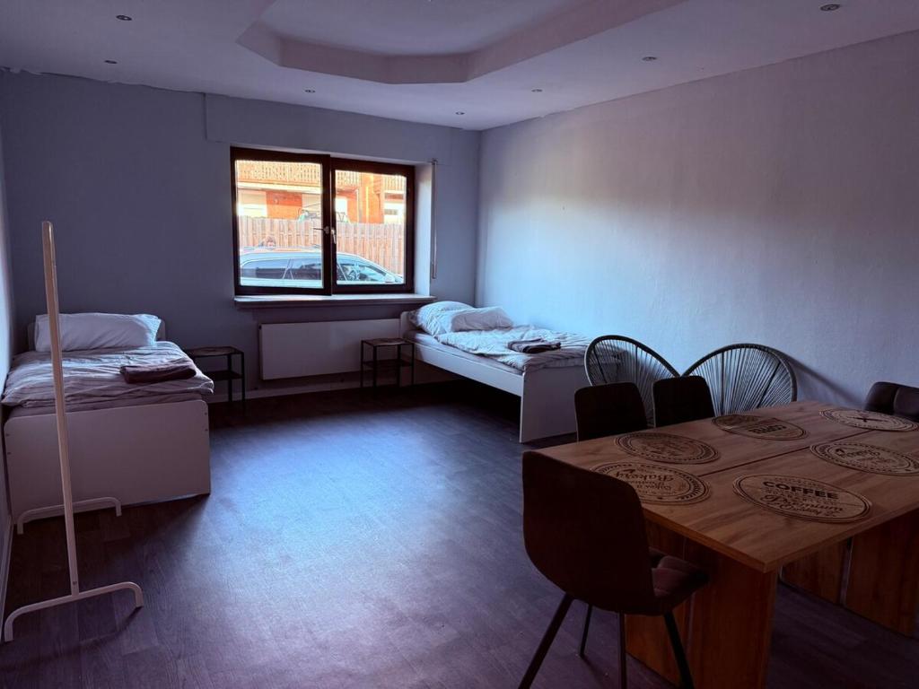 a room with two beds and a table and a window at FeWo 5Z Terasse 2 Bad in Lingen