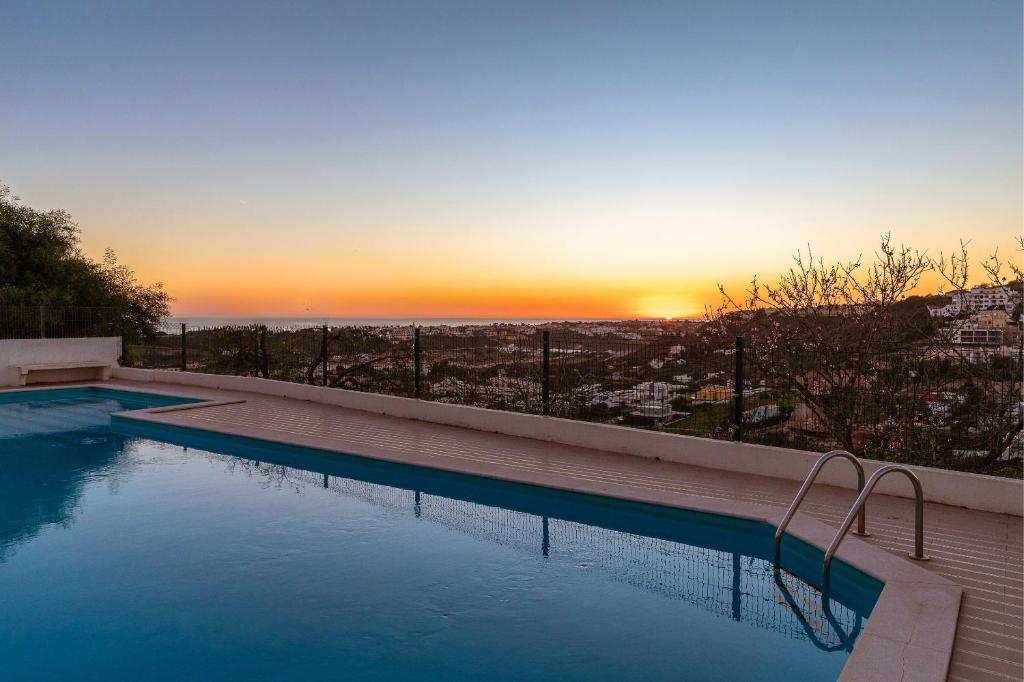 una piscina con puesta de sol en el fondo en Apartamento Sunset on the Sea, en Albufeira