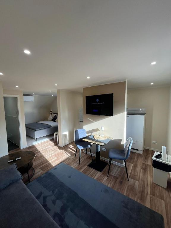 a living room with a couch and a table and chairs at Lumio Apartment 2 - Klimatisiert - Coffee for free - in Karlsruhe