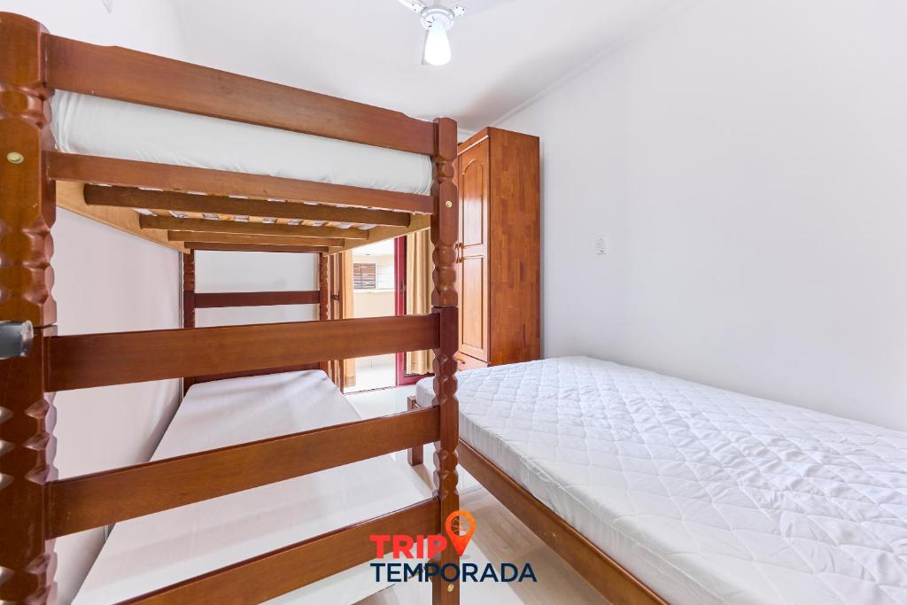 two bunk beds in a room with a window at Apartamento espaçoso com ar condicionado e Wi-fi, a 100 metros da praia - Edifício Estoril in Ubatuba