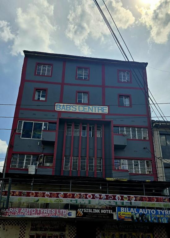 a red building with a sign on the side of it at Sislink Babs Centre Hotel in Nairobi
