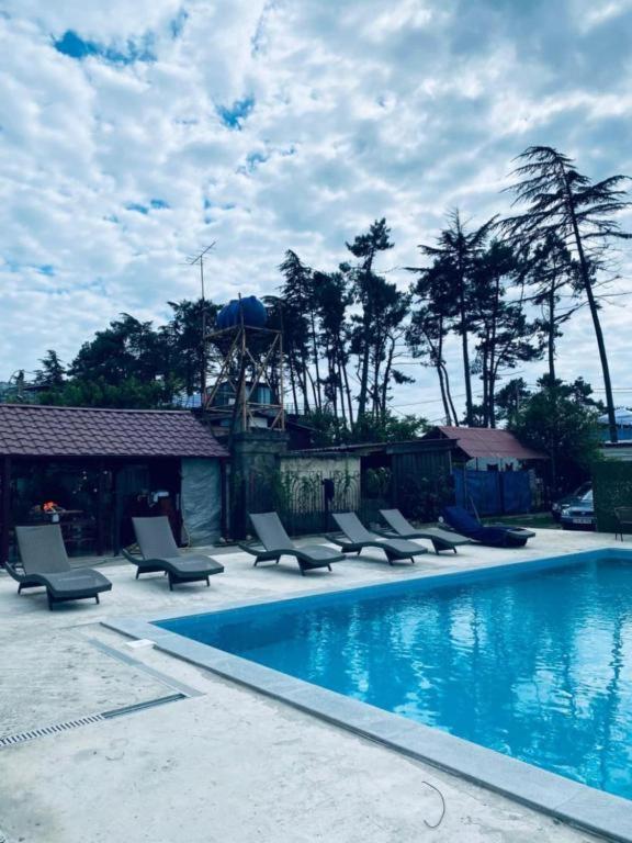a swimming pool with chaise lounge chairs and a swimming pool at Villas David in Ureki