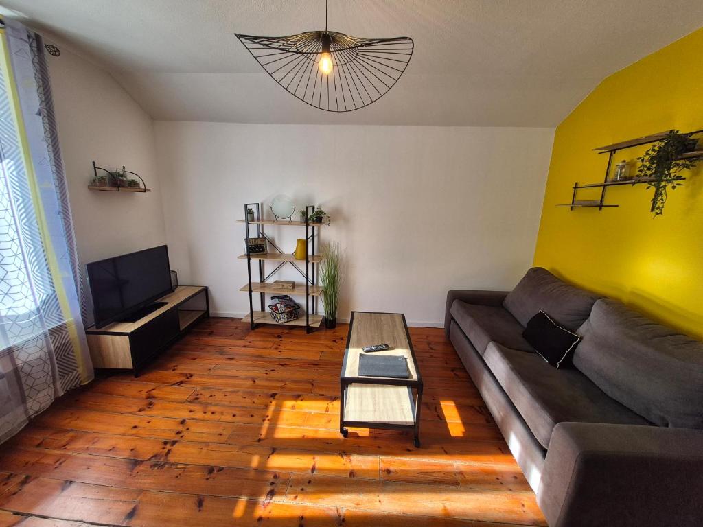 a living room with a couch and a table at L'industriel - Lourdes Centre in Lourdes