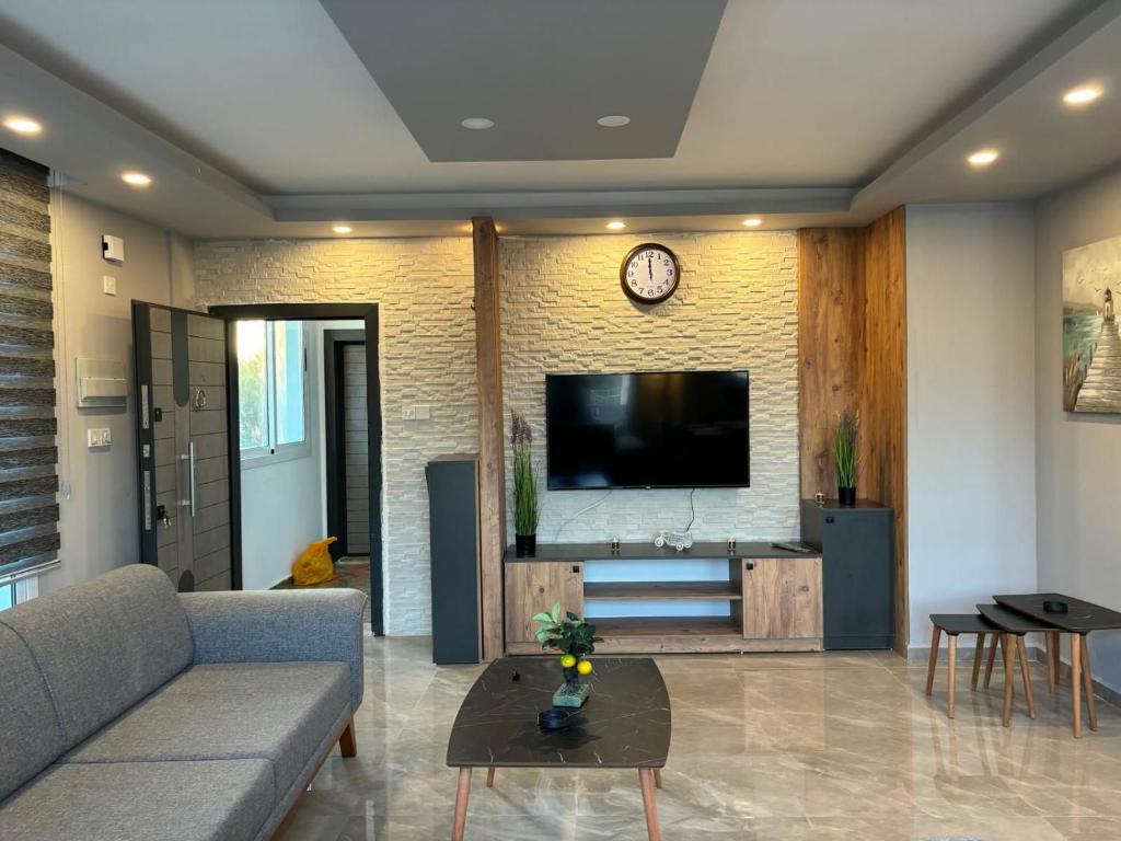 a living room with a couch and a flat screen tv at Veray Homes, Alsancak in Ayios Dhometios