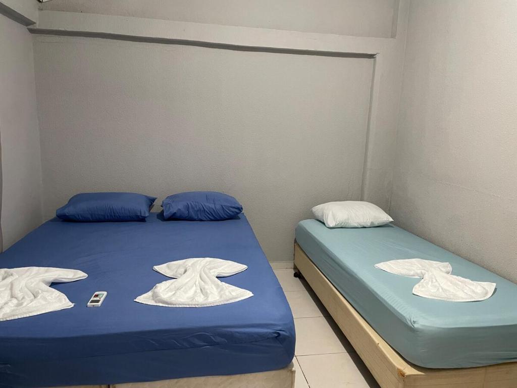 Casa Confortável e Prática de 1 Quarto acomoda até 5 pessoas في فوز دو إيغواسو: سريرين في غرفة صغيرة عليها مناشف