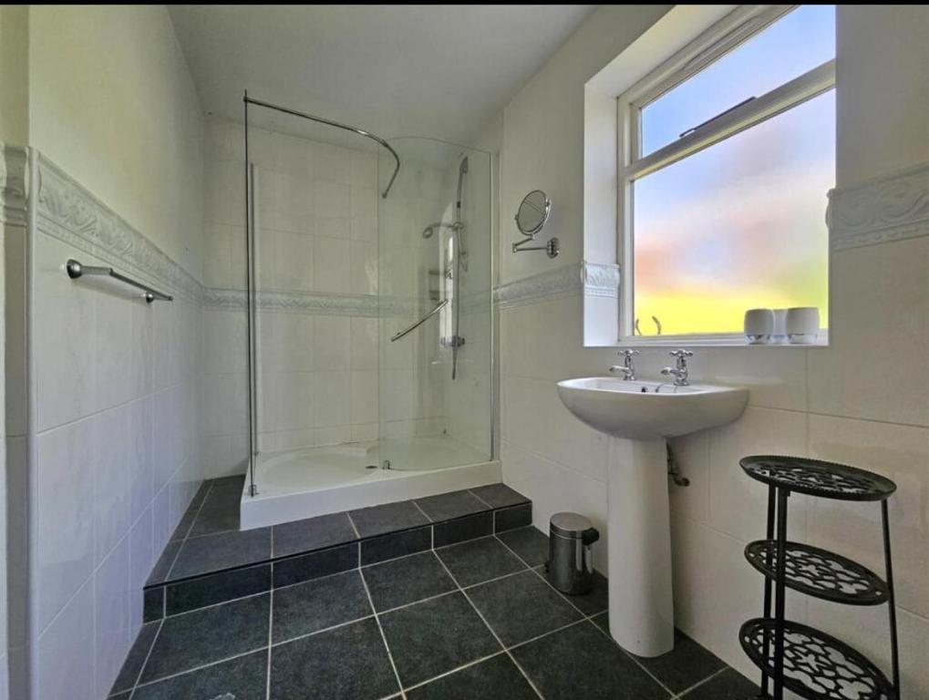 Spacious Home - Solihull Town Centre- Near NEC-BHX في سوليهال: حمام أبيض مع حوض ودش