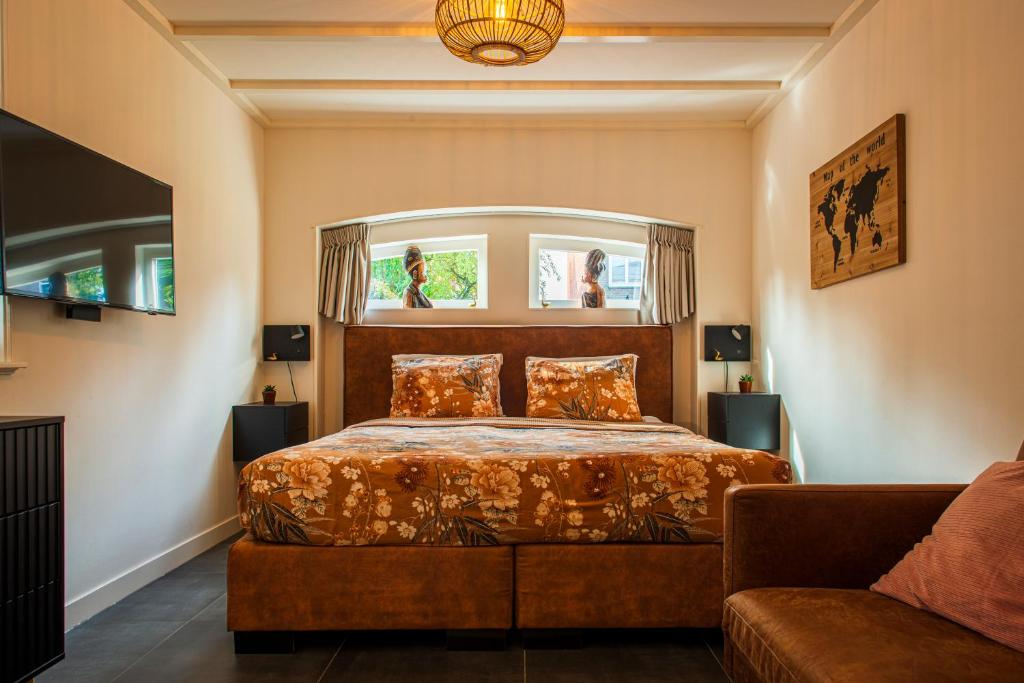 a bedroom with a bed and a couch at Het prinsentuintje in Leeuwarden