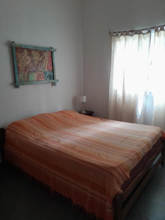 a large bed in a bedroom with a window at Vientoafavorcabanas in Chascomús
