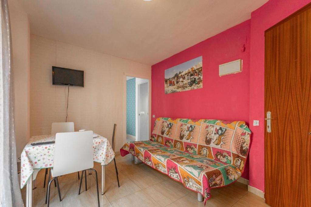 a room with a couch and a table and a red wall at Duque Center Premium Suites in Seville
