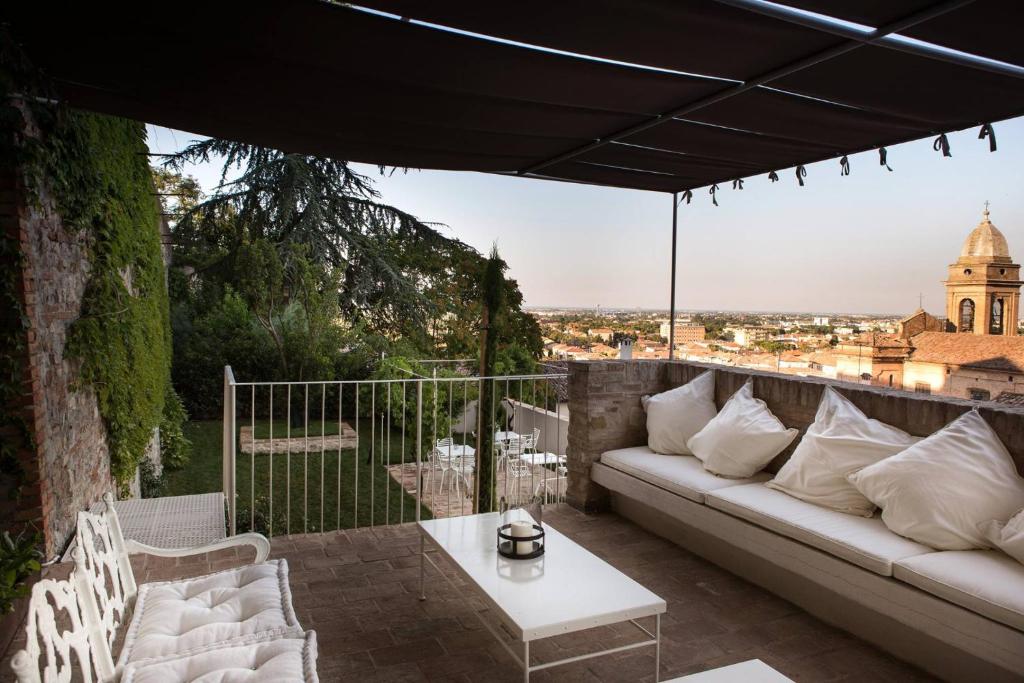 eine Couch auf einer Terrasse mit Blick auf die Stadt in der Unterkunft Le Contrade - Dimora nel Borgo in Santarcangelo di Romagna